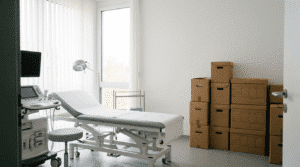 Behandlungszimmer einer Arztpraxis mit Umzugskartons bei einer Praxisauflösung